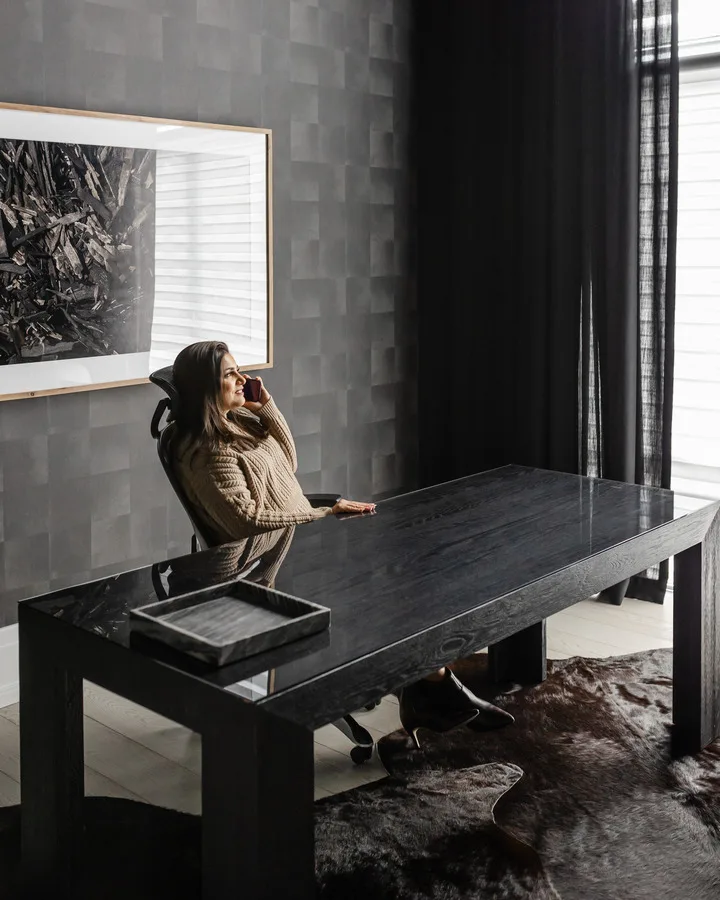 Ravi Gill seated at a black desk in a dark, textured study